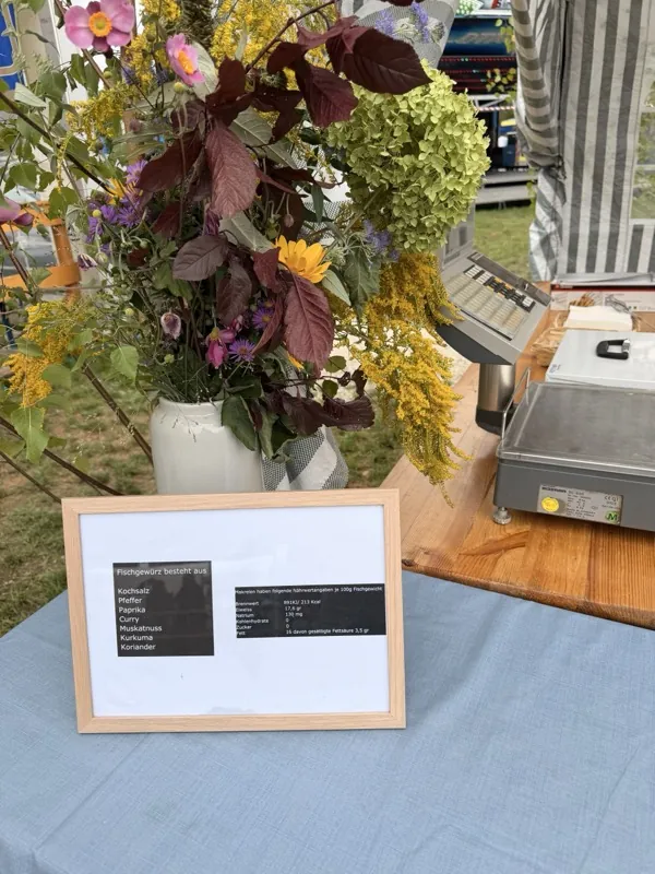 Blumenstrauß auf der Theke, daneben der gerahmte Aushang mit Gewürz- und Nährwertangaben